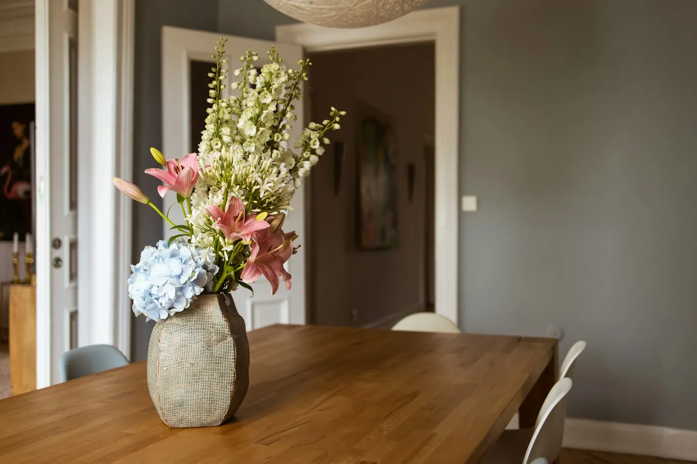 Grand vase de fleurs posé sur une table en bois massif